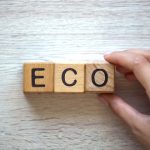 Woman making eco word of cubes, goods and services with no harm to ecosystem